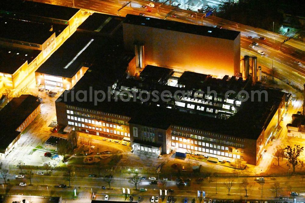 Aerial image at night Berlin - Night lighting building and production halls on the premises of Procter & Gamble Manufacturing Berlin GmbH on Oberlandstrasse in the district Tempelhof-Schoeneberg in Berlin, Germany