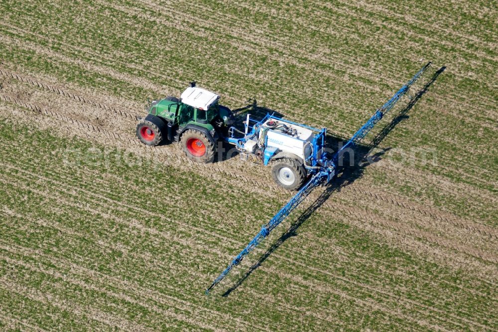 Aerial photograph Friedland - Spraying fertilizer with tractor and tank trailer on agricultural fields in Friedland in the state Lower Saxony, Germany