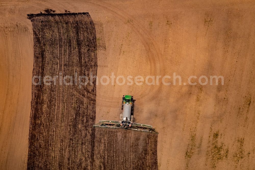 Altendorf-Ulfkotte from above - Spraying manure as fertilizer with tractor and tank trailer on agricultural fields in Altendorf-Ulfkotte in the state North Rhine-Westphalia, Germany