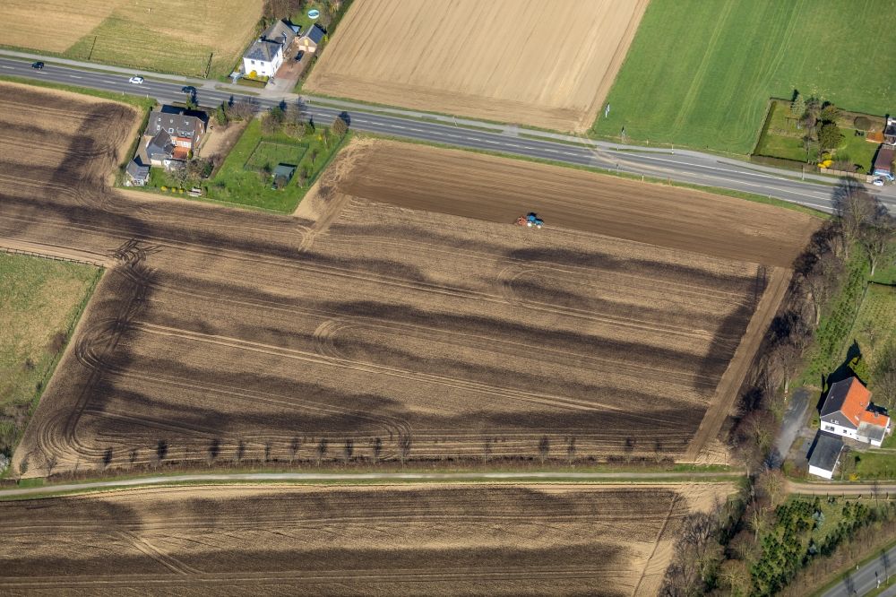 Friedrichsfeld from above - Spraying manure as fertilizer with tractor and tank trailer on agricultural fields in Friedrichsfeld in the state North Rhine-Westphalia, Germany