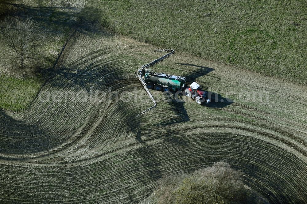 Aerial photograph Kaltenwestheim - Spraying manure as fertilizer with tractor and tank trailer on agricultural fields in Kaltenwestheim in the state Thuringia, Germany