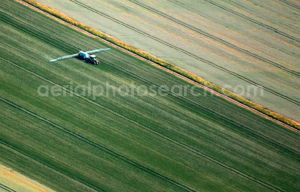 Schwerstedt from the bird's eye view: Spraying Pesticidial with tractor on agricultural fields in Henschleben in the state Thuringia, Germany