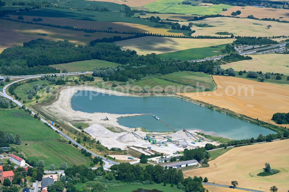 Aerial image Zurow - Lake shore and overburden areas of the quarry lake and gravel open pit Heidelberger Sand and Kies GmbH in Zurow in the state Mecklenburg - Western Pomerania, Germany