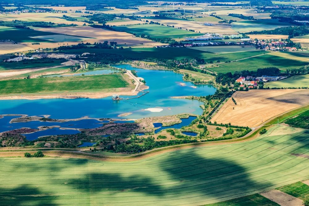Staritz from above - Lake shore and overburden areas of the quarry lake and gravel open pit Huelskens in the district Liebersee in Staritz in the state Saxony, Germany