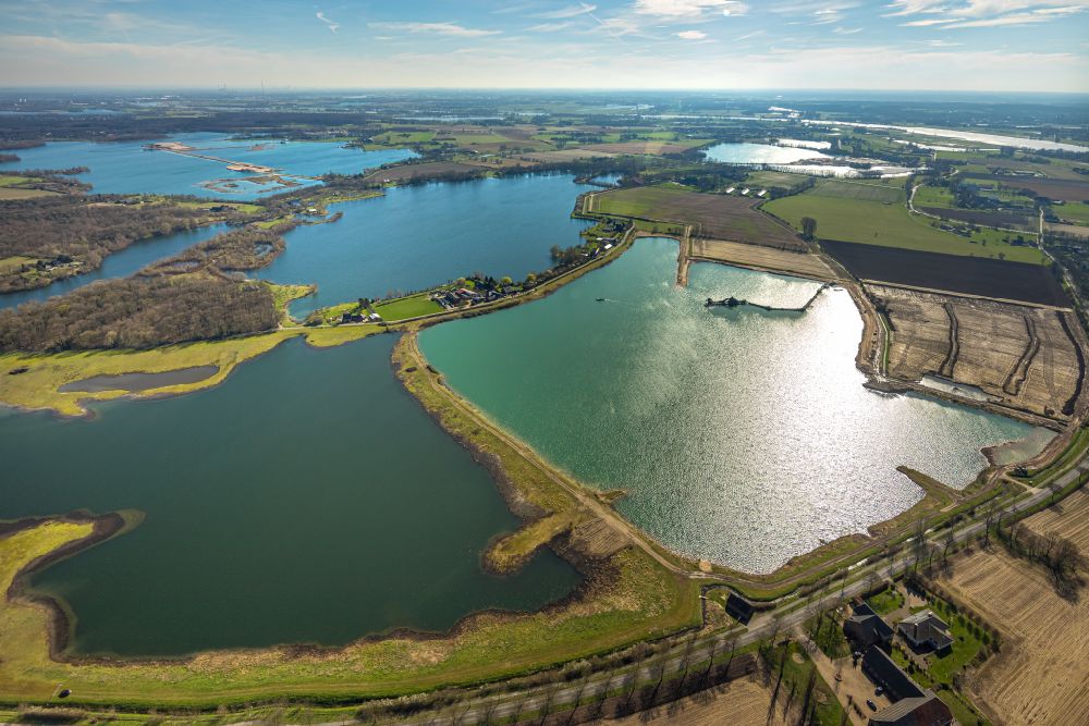 Aerial photograph Wesel - Lake shore and overburden areas of the quarry lake and gravel open pit Holemans - Kieswerk Bergerfurth on street Bergen in the district Bergen in Wesel at Ruhrgebiet in the state North Rhine-Westphalia, Germany