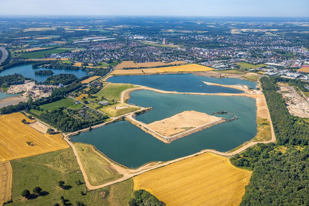Kamp-Lintfort from the bird's eye view: Lake shore and overburden areas of the quarry lake and gravel open pit of Heidelberger Sand and Kies GmbH in Kamp-Lintfort at Ruhrgebiet in the state North Rhine-Westphalia, Germany