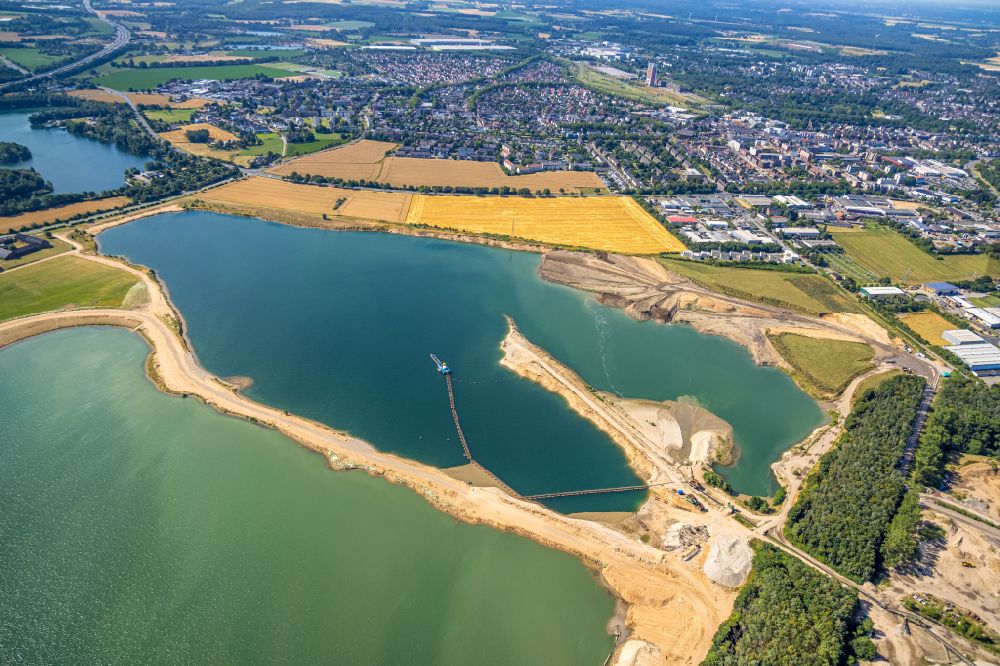 Aerial image Kamp-Lintfort - Lake shore and overburden areas of the quarry lake and gravel open pit of Heidelberger Sand and Kies GmbH in Kamp-Lintfort at Ruhrgebiet in the state North Rhine-Westphalia, Germany