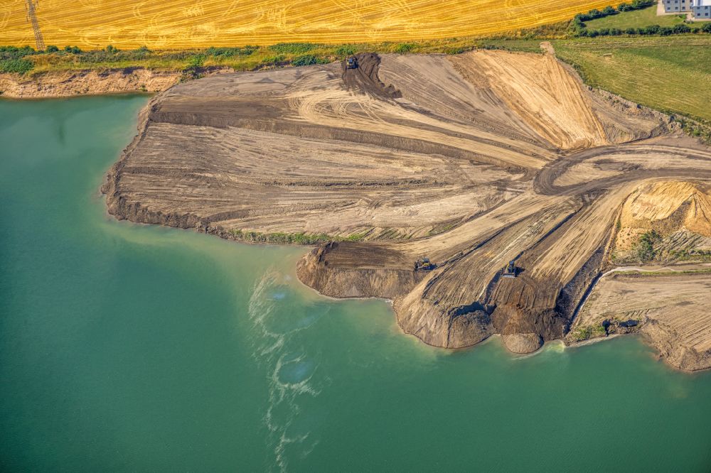 Aerial photograph Kamp-Lintfort - Lake shore and overburden areas of the quarry lake and gravel open pit of Heidelberger Sand and Kies GmbH in Kamp-Lintfort at Ruhrgebiet in the state North Rhine-Westphalia, Germany
