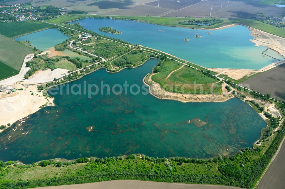 Wörbzig from the bird's eye view: Lake shore and overburden areas of the quarry lake and gravel open pit of Mitteldeutsche Baustoffe GmbH in Woerbzig in the state Saxony-Anhalt, Germany