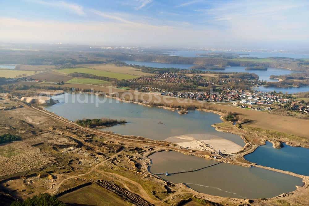 Pinnow from the bird's eye view: Lake shore and overburden areas of the quarry lake and gravel open pit Pinnower Kiessee in Pinnow in the state Mecklenburg - Western Pomerania, Germany
