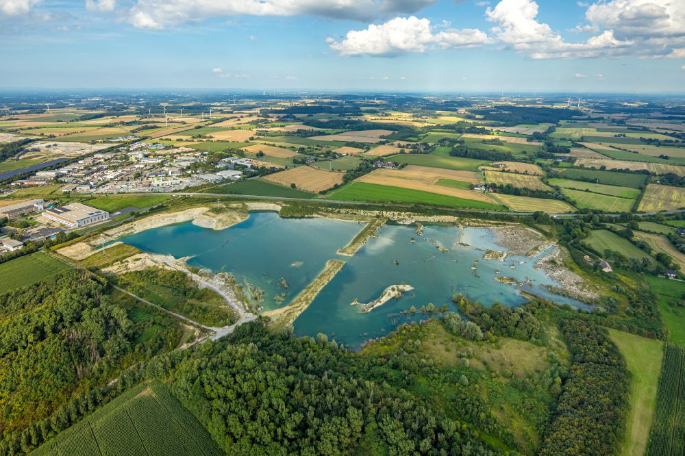 Beckum from the bird's eye view: Lake shore and overburden areas of the quarry lake and gravel open pit of P H O E N I X Zementwerke in Beckum at Ruhrgebiet in the state North Rhine-Westphalia, Germany