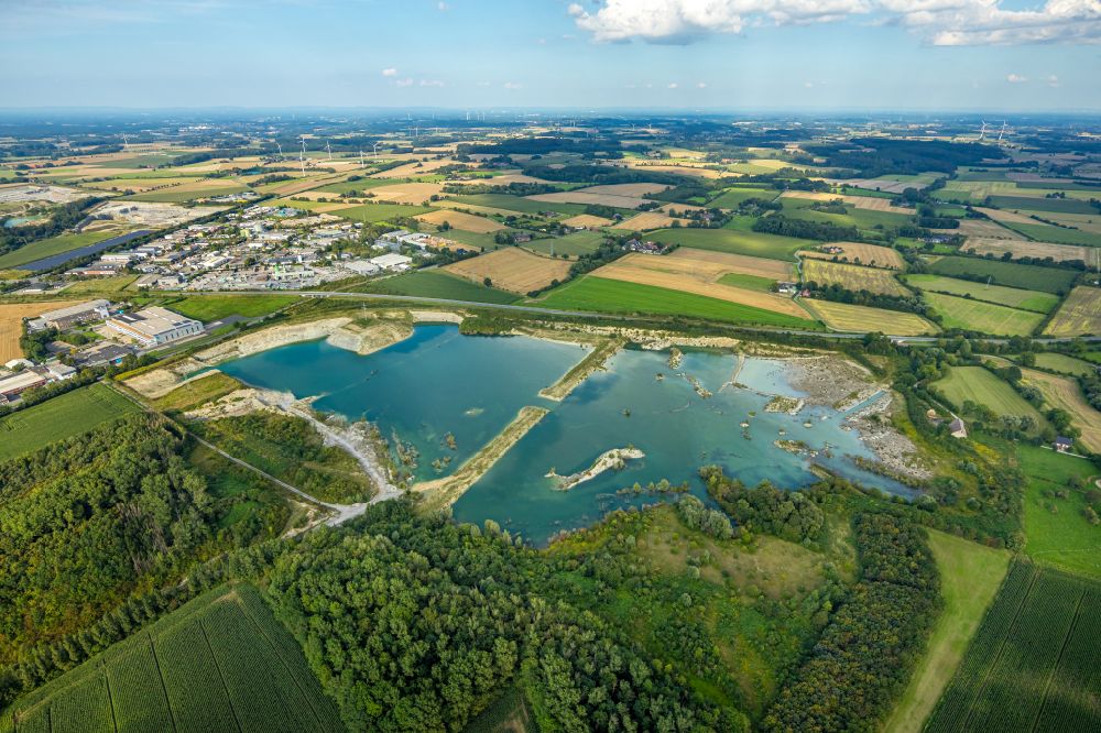 Aerial image Beckum - Lake shore and overburden areas of the quarry lake and gravel open pit of P H O E N I X Zementwerke in Beckum at Ruhrgebiet in the state North Rhine-Westphalia, Germany