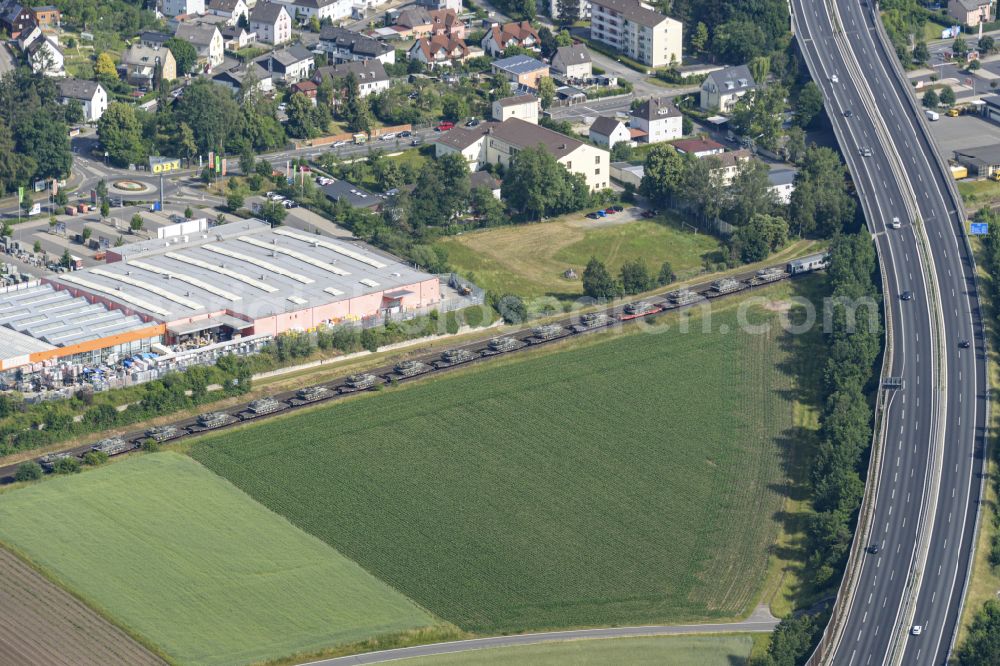 Aerial image Weiden in der Oberpfalz - Driving a train with wagons for the rail transport of tanks - battle tanks M1 Abrams in freight traffic on the track route in the district Ullersricht in Weiden in der Oberpfalz in the state Bavaria, Germany