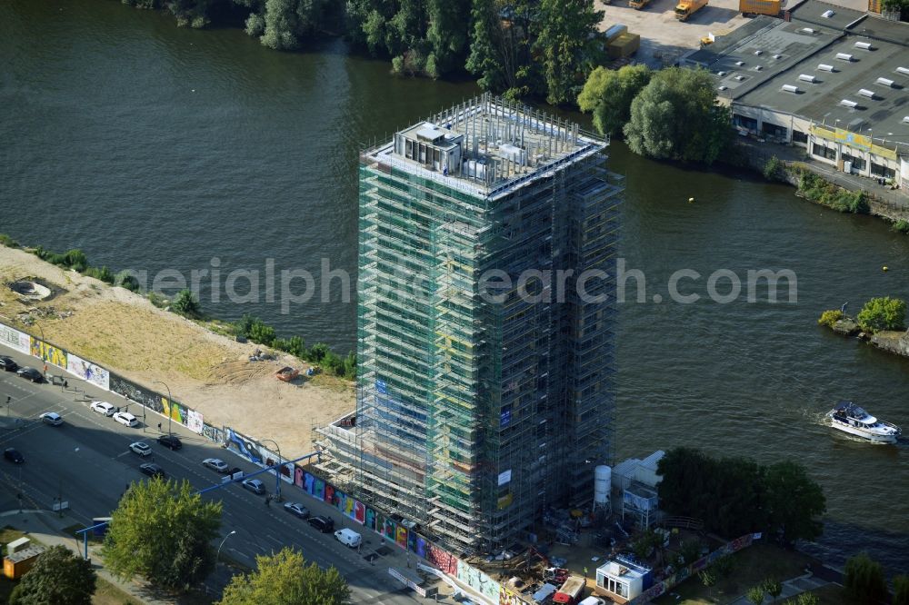 Aerial photograph Berlin - Construction site of Project Living Levels at Muhlenstrasse on the banks of the River Spree in Berlin - Friedrichshain. On the grounds of the Berlin Wall border strip at the EastSideGallery, the company Living Bauhaus is building a futuristic high-rise residential. The real estate service company City & Home GmbH manages the available apartments