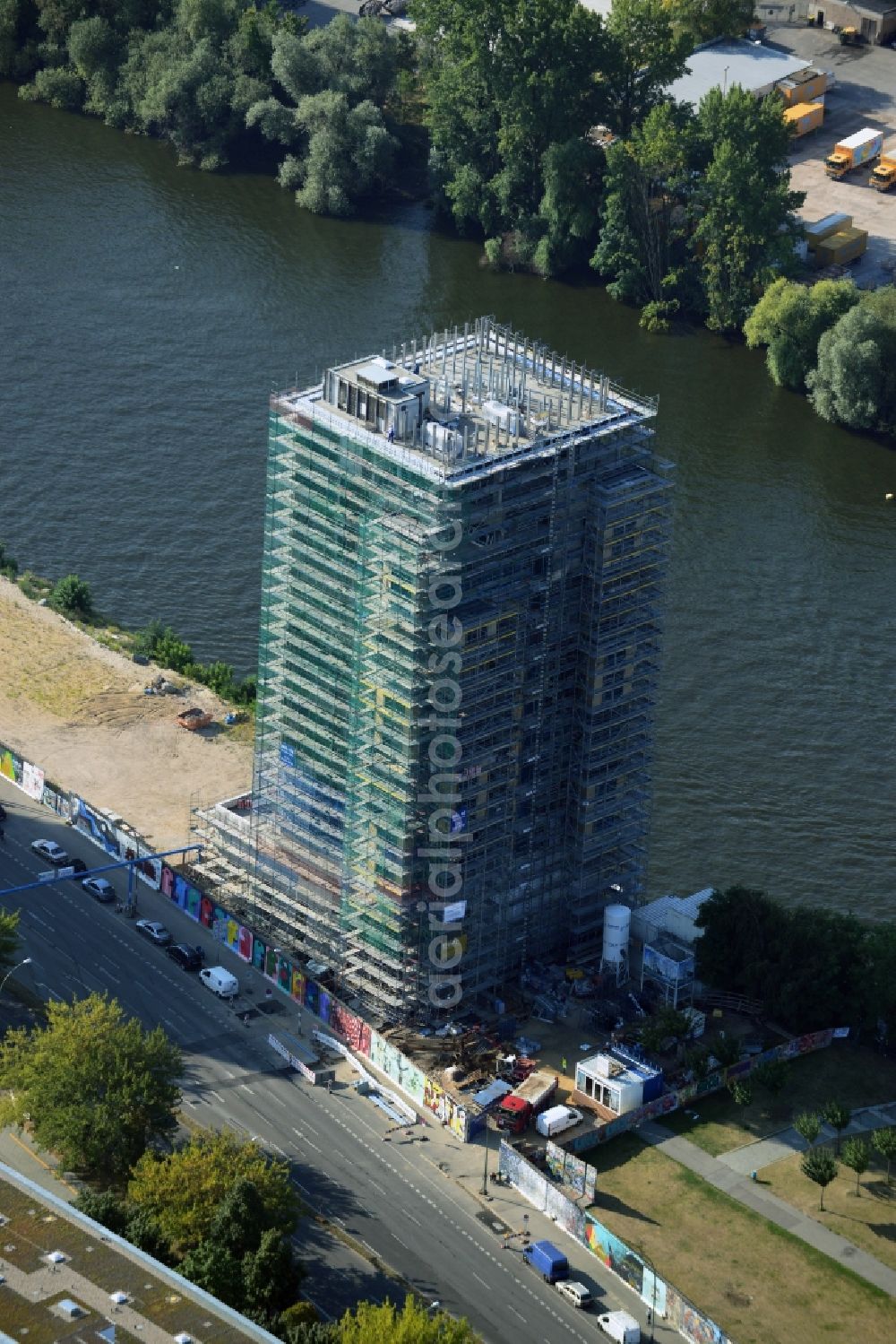 Berlin from above - Construction site of Project Living Levels at Muhlenstrasse on the banks of the River Spree in Berlin - Friedrichshain. On the grounds of the Berlin Wall border strip at the EastSideGallery, the company Living Bauhaus is building a futuristic high-rise residential. The real estate service company City & Home GmbH manages the available apartments