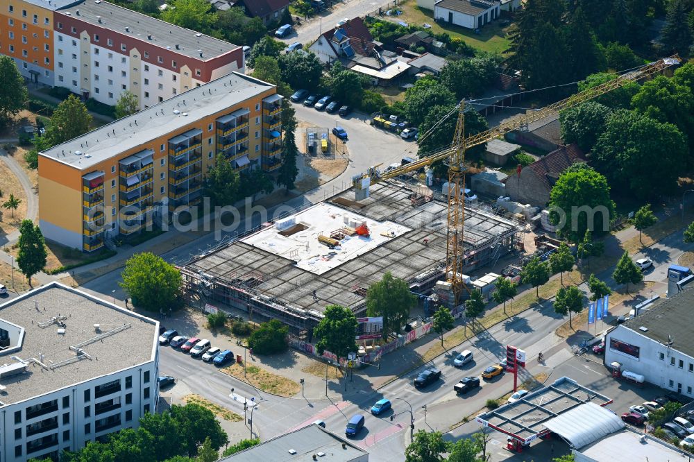Oranienburg from the bird's eye view: Construction site for the new construction of the building complex of a residential complex with an integrated local supply center MAXNAT on street Berliner Strasse - Walther-Bothe-Strasse in Oranienburg in the state Brandenburg, Germany