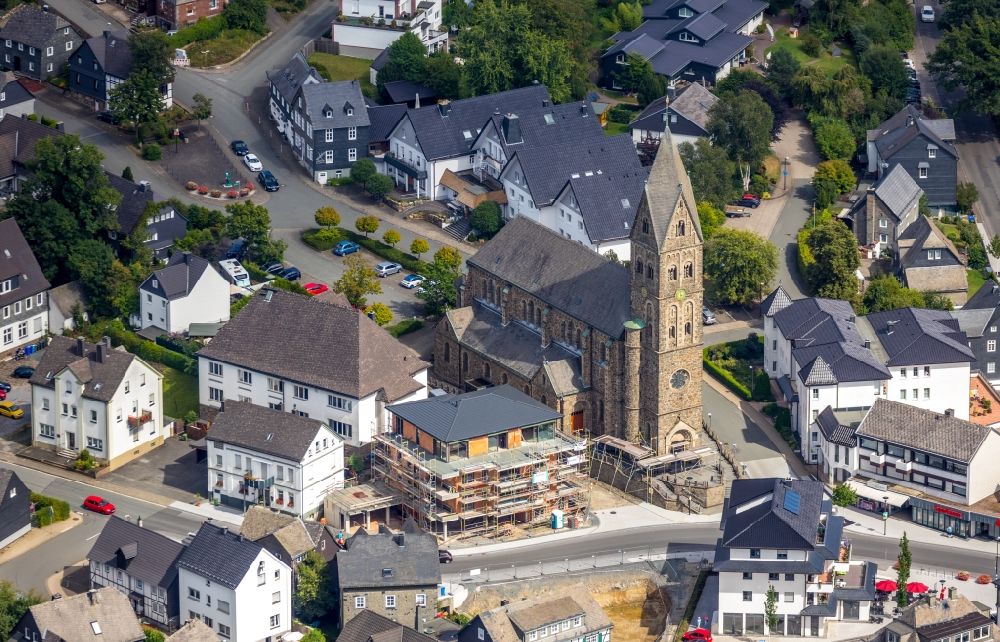 Aerial image Olsberg - Construction site for the multi-family residential building on Bahnhofstrasse - Kirchstrasse overlooking the church building of the Pfarrkirche Sankt Nikolaus in Olsberg in the state North Rhine-Westphalia, Germany