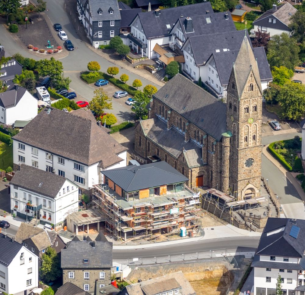 Aerial photograph Olsberg - Construction site for the multi-family residential building on Bahnhofstrasse - Kirchstrasse overlooking the church building of the Pfarrkirche Sankt Nikolaus in Olsberg in the state North Rhine-Westphalia, Germany
