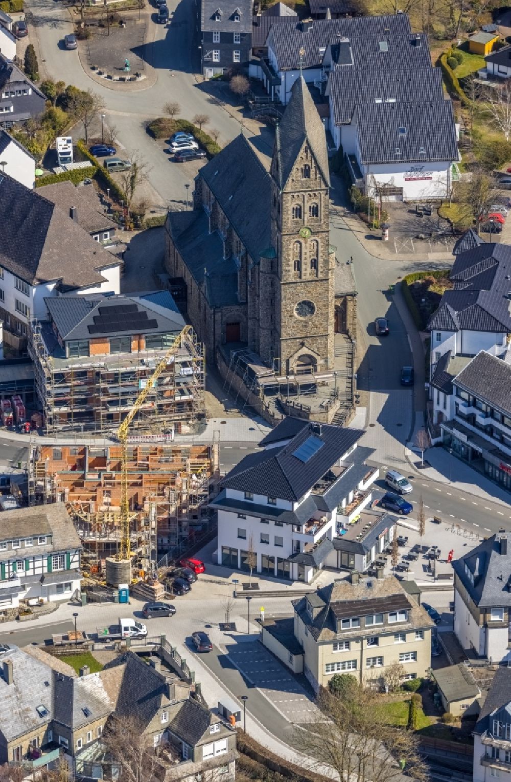 Aerial photograph Olsberg - Construction site for the multi-family residential building on Bahnhofstrasse - Kirchstrasse overlooking the church building of the Pfarrkirche Sankt Nikolaus in Olsberg in the state North Rhine-Westphalia, Germany