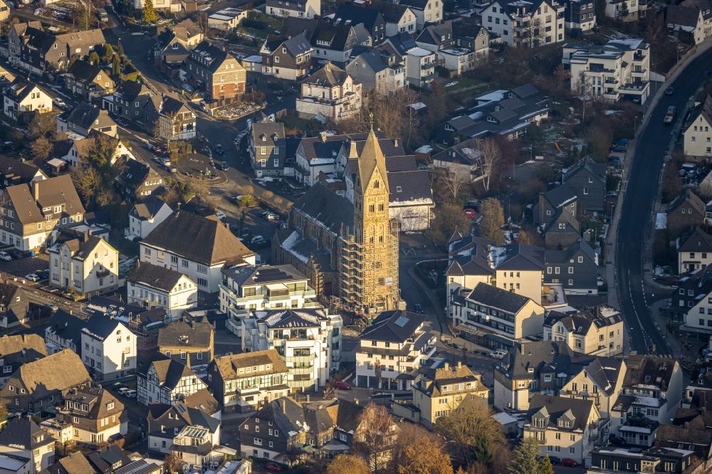 Olsberg from the bird's eye view: Construction site for the multi-family residential building on Bahnhofstrasse - Kirchstrasse overlooking the church building of the Pfarrkirche Sankt Nikolaus in Olsberg in the state North Rhine-Westphalia, Germany