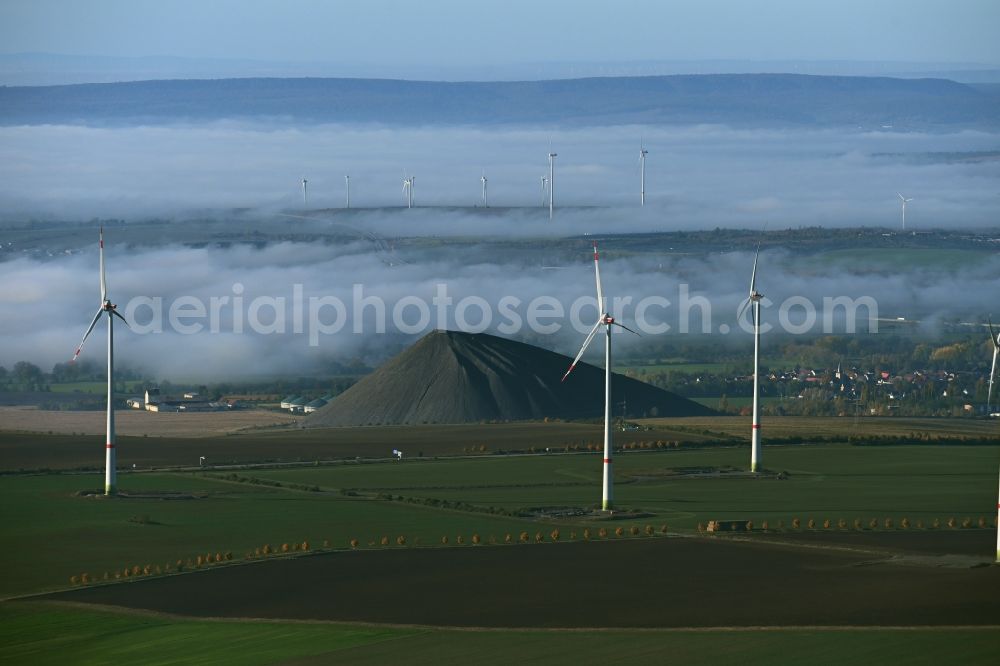 Niederröblingen (Helme) from above - Layers of a mining waste dump of copper mining in front of a layer of high fog in Niederroeblingen (Helme) Mannsfelder Land in the state Saxony-Anhalt, Germany