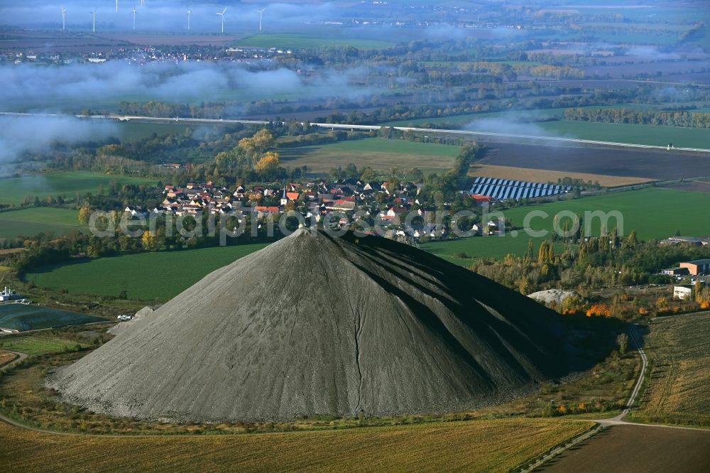 Niederröblingen (Helme) from above - Layers of a mining waste dump of copper mining in front of a layer of high fog in Niederroeblingen (Helme) Mannsfelder Land in the state Saxony-Anhalt, Germany