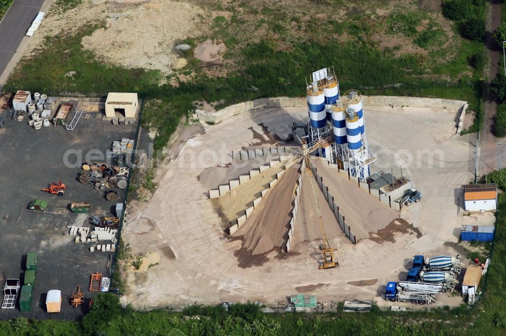 Apolda from above - The cement mixing plant BERGER HOLDING GMBH located in the industrial area on the B87 in Apolda in Thuringia. In the modern stationary mixing plant Concrete is produced in different grades. Aggregates with different grain sizes are provided in the depots. The car park with truck mixers with auto- shear flow media dosage and truck-mounted concrete pump is ready