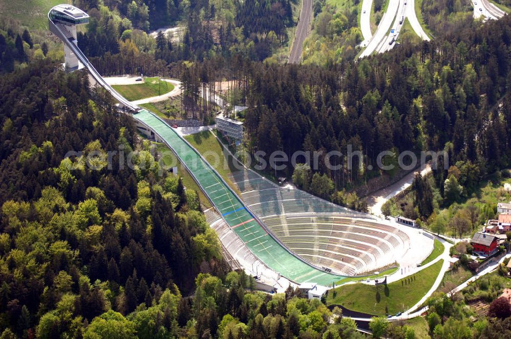 Aerial photograph Innsbruck - Blick auf Bergisel Schanze in Innsbruck. Die Bergiselschanze wurde 2001 von der irakischen Architektin Zaha Hadid anstelle eines Vorgängerbaus errichtet und gilt wegen ihrer Form und der markanten Lage am Bergisel südlich von Innsbruck als neues Wahrzeichen. Sie ist Anfang Januar Schauplatz der internationalen Vierschanzentournee. Von der Stadionanlage gelangt man mit einem Schrägaufzug zum Sprungturm und von dort zu einer Plattform, wo sich ein Ausblick auf die Stadt und die umliegenden Berge ergibt. Hoch am Sprungturm lädt auch ein Cafe ein. Kontakt: SC Bergisel, Bergiselweg 3, 6020 Innsbruck, Tel. +43 (0)512 575690, Fax. +43 (0)512 560935, E-Mail: office@bergisel.info