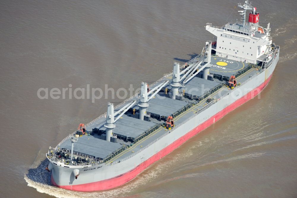 Aerial photograph Brokdorf - View of the bulk carrier Britain Bay on the Elbe near the town of Brokdorf in the state of Schleswig-Holstein. The cargo ship was built in 2012 by Kawasaki Sakaide Works and belongs to K Line Bulk Shipping Uk