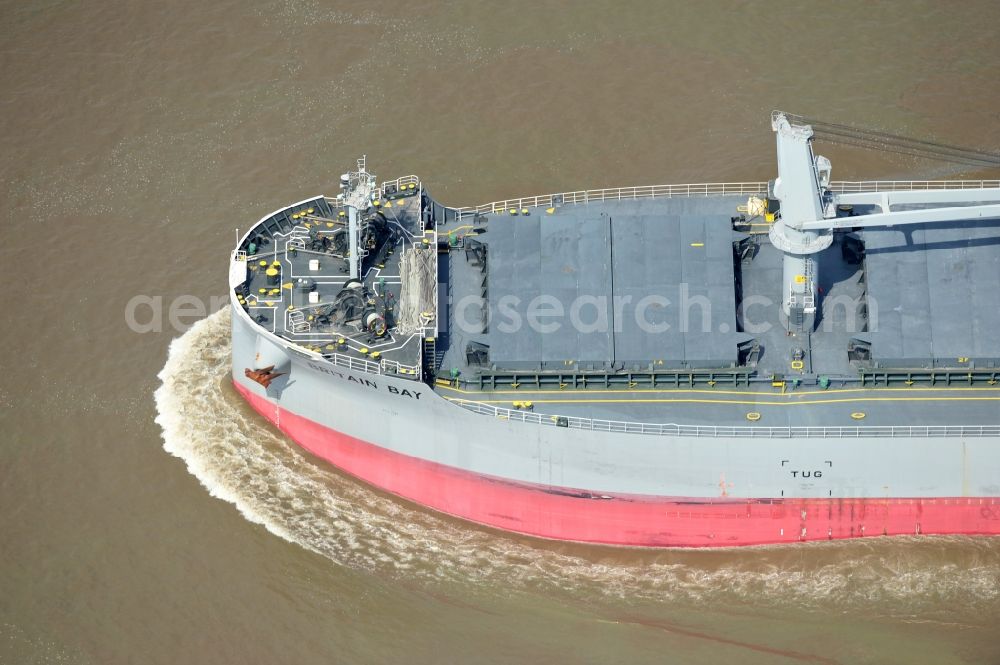 Brokdorf from above - View of the bulk carrier Britain Bay on the Elbe near the town of Brokdorf in the state of Schleswig-Holstein. The cargo ship was built in 2012 by Kawasaki Sakaide Works and belongs to K Line Bulk Shipping Uk