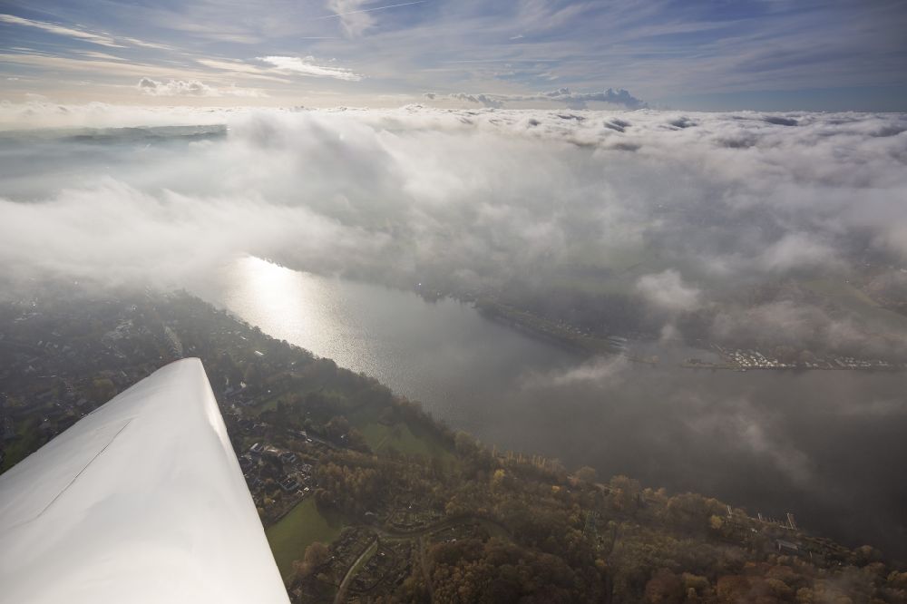 Aerial photograph Essen - Overlooking an airplane wing over the Ruhr peninsular Heisingen with a view of the lake Baldeneysee and the Essen district Fischlaken covered with a thick layer of autumn weather fog and clouds in the state North Rhine-Westphalia