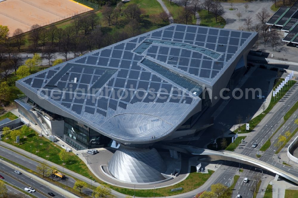 Aerial image München - The BMW Welt is a combined exhibition, delivery, adventure, museum and event venue in Munich in Bavaria and is part of the corporate headquarters of the car manufacturer BMW. In the so-called brand world, an exhibition pavilion, the current models of BMW, MINI, Rolls-Royce Motor Cars and BMW Motorrad, innovations and technology are presented. On the roof of the multifunctional building a solar power plant produces electricity
