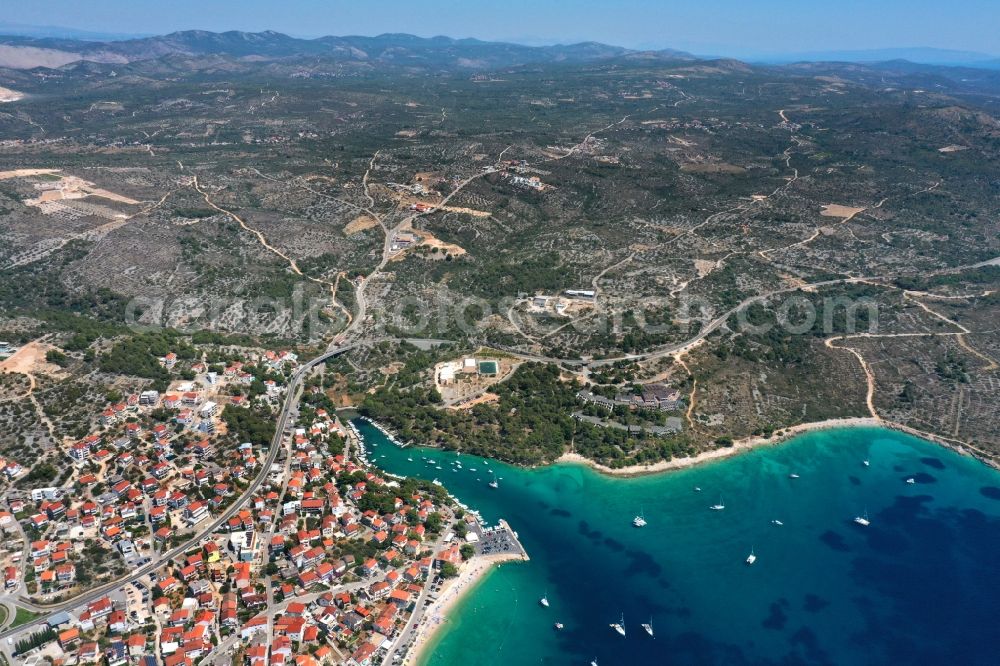 Aerial image Primosten - Water surface at the bay along the sea coast Adriatic Sea in Primosten in Sibensko-kninska zupanija, Croatia