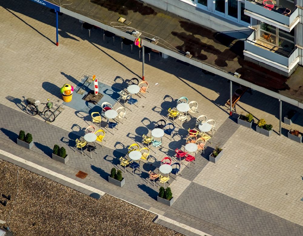 Neukirchen-Vluyn from the bird's eye view: Colourful chairs and tables in front of the ice cream place on Vluyner Platz in Neukirchen-Vluyn in the state of North Rhine-Westphalia