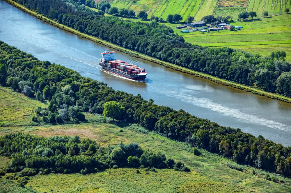 Burg (Dithmarschen) from above - Container ship Nordic Istria on the Kiel Canal in Burg Dithmarschen in the state Schleswig-Holstein, Germany
