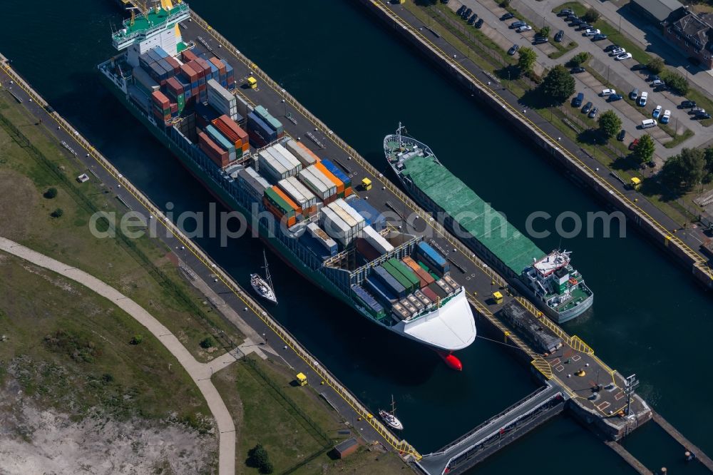 Aerial photograph Kiel - Container ship in the lock systems on the bank of Kiel-Holtenau lock island on the Kiel Canal in Kiel in the state of Schleswig-Holstein
