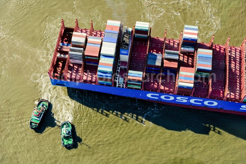 Hamburg from above - Container ship with tugboats in the port in Hamburg, Germany