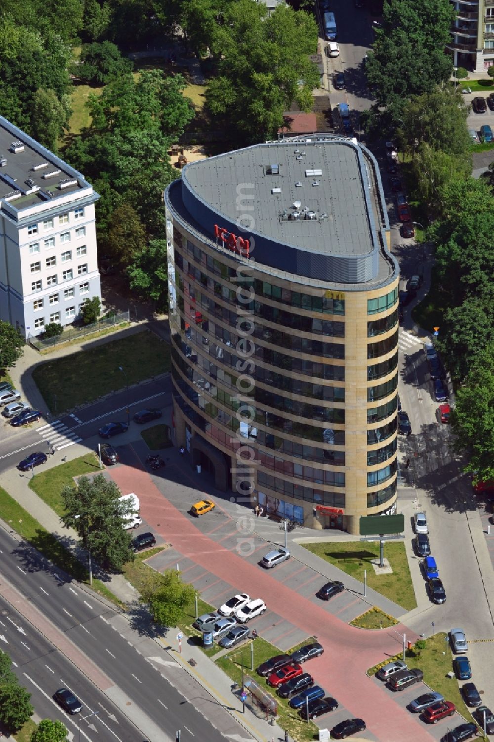 Aerial photograph Warschau - The office building of ICAN Institute in the Ksawerow part of the district of Mokotow in Warsaw in Poland. Inside the building there are several coworking spaces, restaurants and shopping facilities. The distinct building with the round and curvy shapes is located on a street corner surrounded by a parking lot