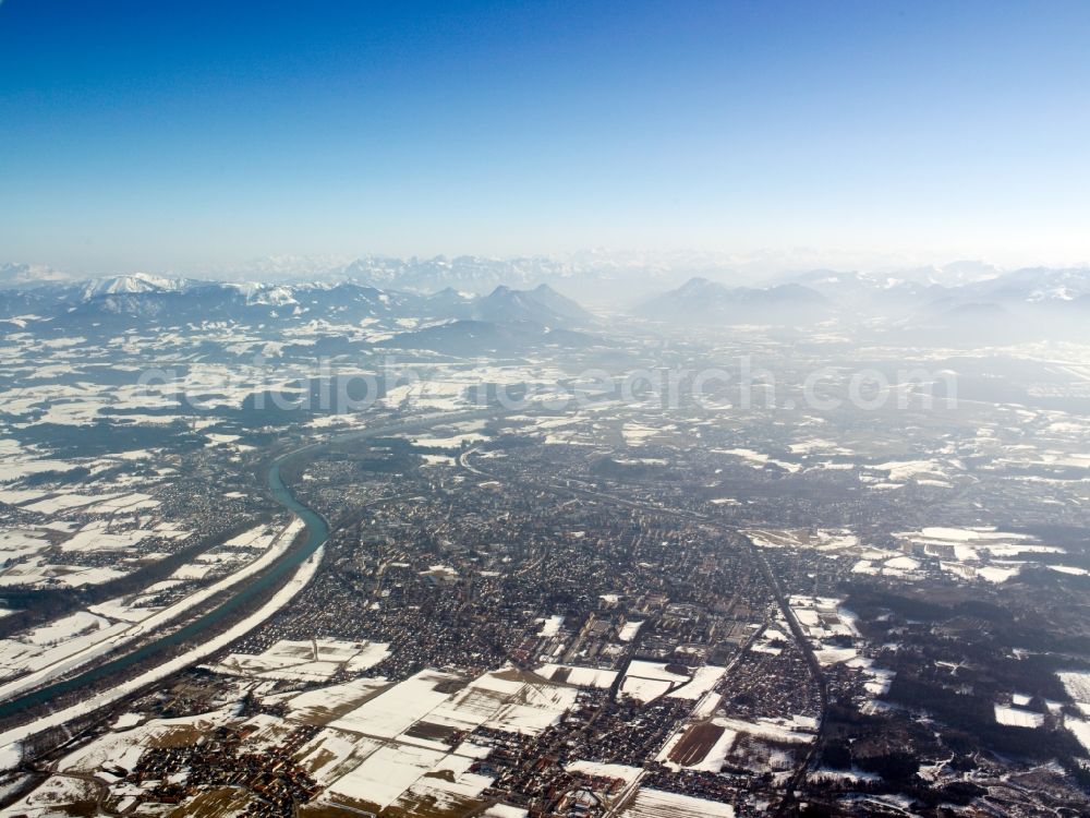 Rosenheim from the bird's eye view: The snowed in and frozen city of Rosenheim in the free state of Bavaria. Overview and landscape of the city and its surrounding environment. Visible in the background are mountains and peaks of the alps. Rosenheim is the thirdlargest city in the region of Oberbayern and is located on the shores of the river Inn