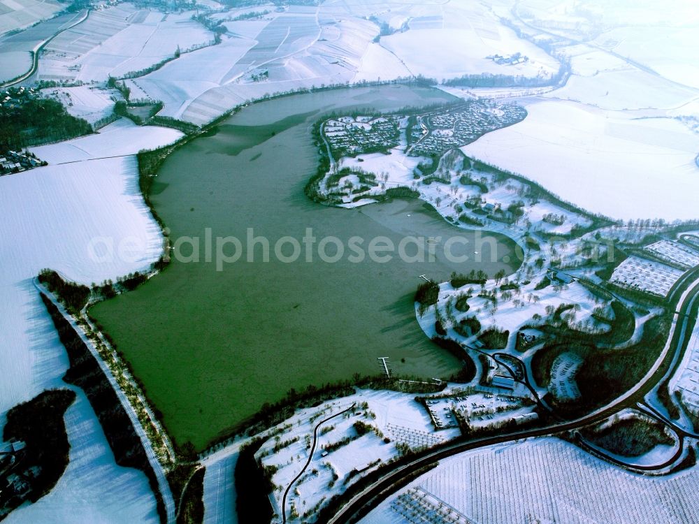 Aerial photograph Obersulm - The lake Breitenauer See in Obersulm in the state of Baden-Württemberg. The snowy lake is a barrier lake used for recreation and swimming. It was created by blocking the river Sulm. It is located in the North Western area of the nature reserve park Swabian Frankian Forest in the landscape protection area of Upper Sulm Valley