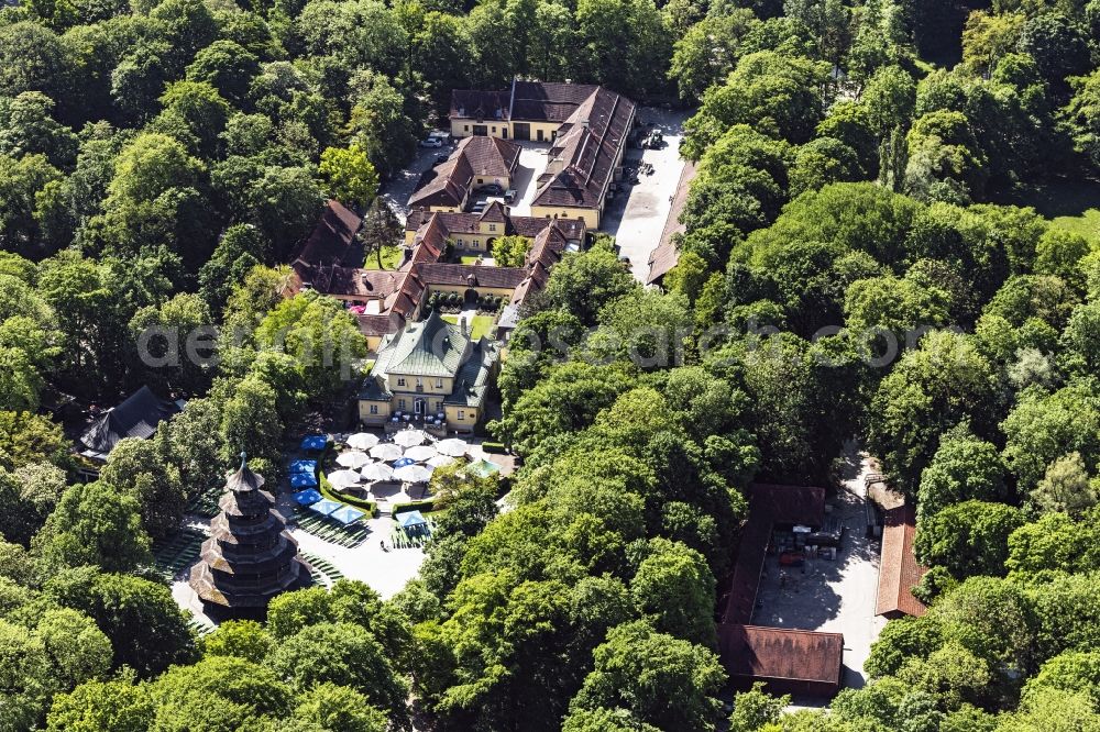 München from above - The Chinese Tower beer garden in English Garden in Munich Schwabing in the state Bavaria. In high summer temperatures hardly any guests can be seen at the tables and benches in the sun. The restaurant is set for a celebration