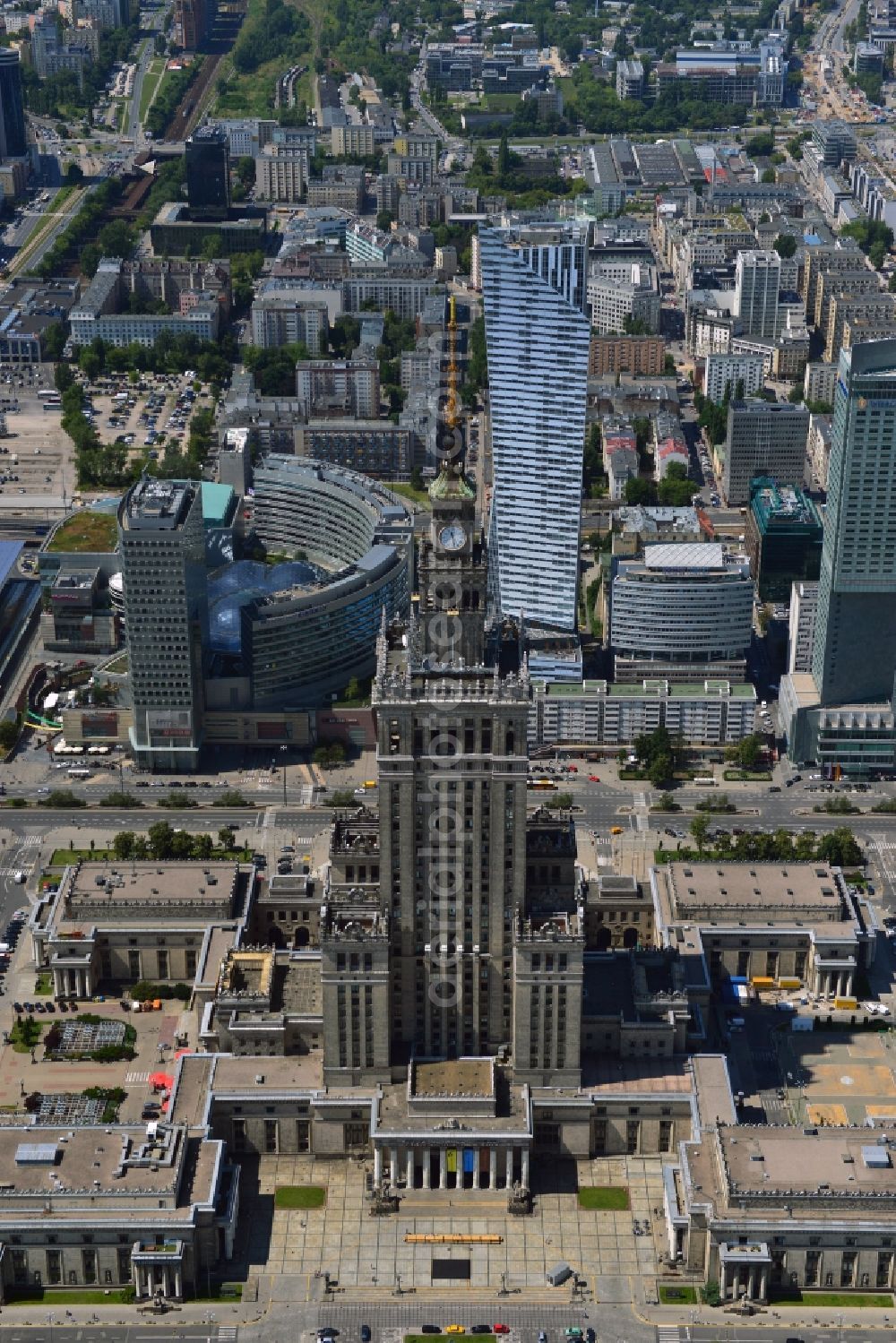 Aerial photograph Warschau - The high-rise building complex of the Palace of Culture and Science (Palac Kultury i Nauki Polish) in downtown Warsaw in Poland. The building and landmark of the city was a gift by the former Soviet Union. It was designed by the architect Lew Rudnew in a socialist classicist style. It is the highest building in Poland and is surrounded by new high rise buildings and towers. Its top is used as an antenna and broadcasting tower for radio, TV and several mobile network operators