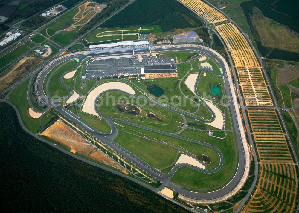 Aerial photograph Klettwitz - The Lausitzring in Klettwitz in the district of Oberspreewald-Lausitz in the state of Brandenburg. It is officially called EuroSpeedway Lausitz and is a permanent race track with a unique Superspeedway. The facilities include several race tracks and variations, including a Grand Prix track for car and motorbikes, but als safe driving test tracks. Apart from race events like the ADAC-Masters-Weekend and races of the DTM and the Porsche Cups, there are also events for inline skaters and cycling