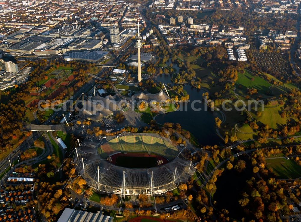 Aerial photograph München - The Olympic Park in Munich in the state of Bavaria. In the foreground lies the Olympic Stadium that is today used for cultural events and concerts. Behind it, the TV tower, the Olympic Tower, one of the landmarks of the city is visible. The large park and lake form one of the largest open spaces in Munich