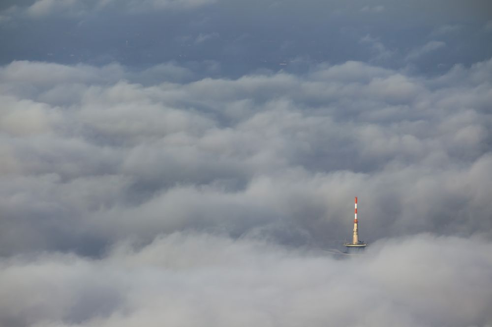 Aerial photograph Essen - View of the top of the telecommunication tower breaking through an impressive blanket of clouds over the city center of Essen in the state North Rhine-Westphalia. The autumn weather clouds are surrounding the television tower at its location in the Holsterhausen district and form a cloud bank over the Ruhr region city