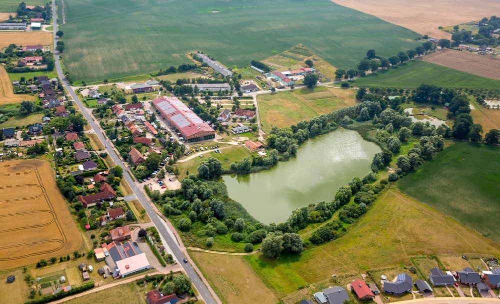 Bollewick from above - Village view of Bollewick with the historical barn of Bollewick on its pond in the state of Mecklenburg - Western Pomerania. Germany's largest cobblestone barn is home to shops and workshops of arts and craft producers