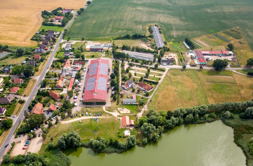 Bollewick from the bird's eye view: Village view of Bollewick with the historical barn of Bollewick on its pond in the state of Mecklenburg - Western Pomerania. Germany's largest cobblestone barn is home to shops and workshops of arts and craft producers