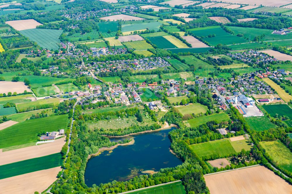 Müssen from the bird's eye view: Village - view on the edge of forested areas in Muessen in the state Schleswig-Holstein, Germany
