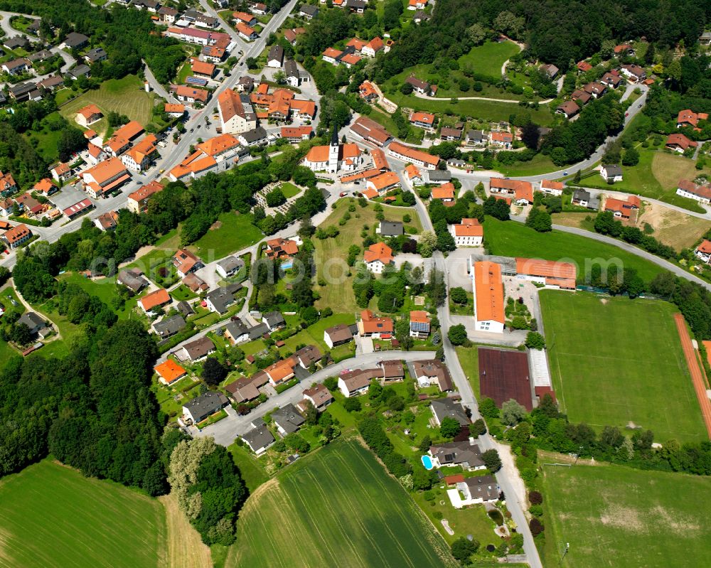Reischach from the bird's eye view: Village - view on the edge of forested areas in Reischach in the state Bavaria, Germany