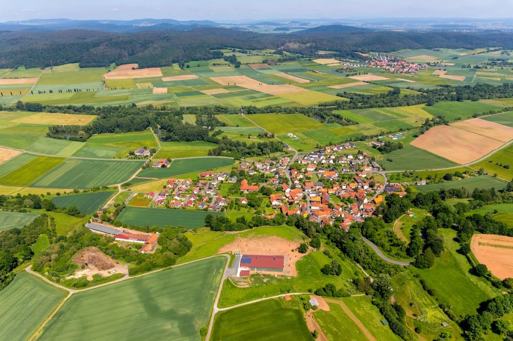 Anraff from above - Agricultural land and field borders surround the settlement area of the village in Anraff in the state Hesse, Germany